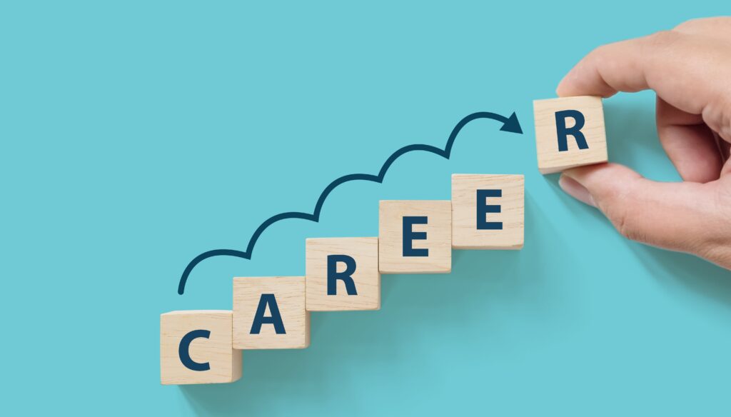 Hand putting wooden cube block on blue background with word CAREER and copy space for your text. Business career planning growth to success concept